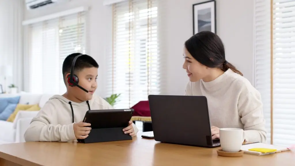 Young adult asian mother and kid stay home work and learning online